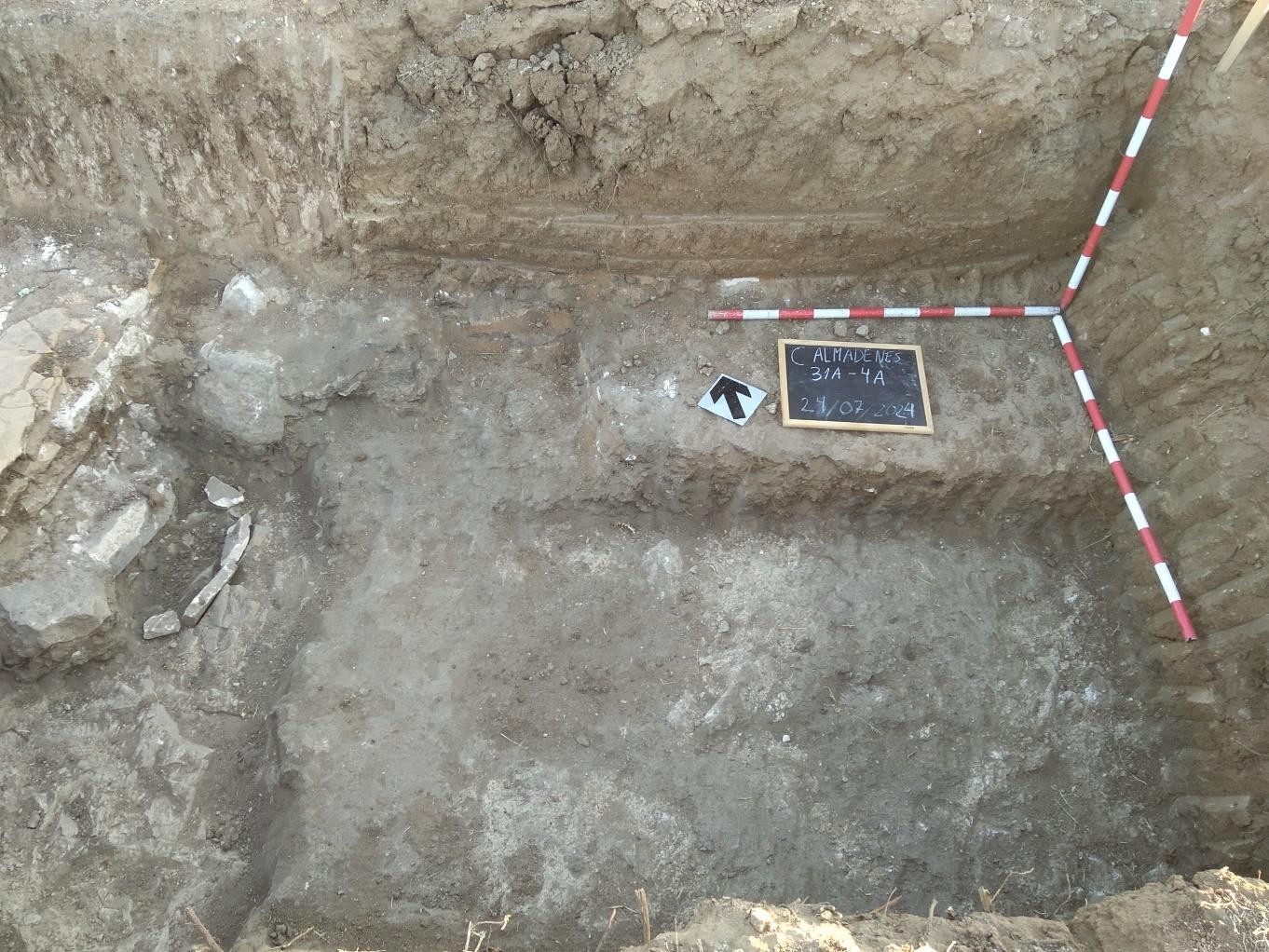 A la izquierda fragmentos de losas de calizas que marcan el límite de la atarjea y a la derecha restos del suelo sobre la roca madre